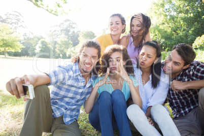 Smiling friends in the park taking selfie