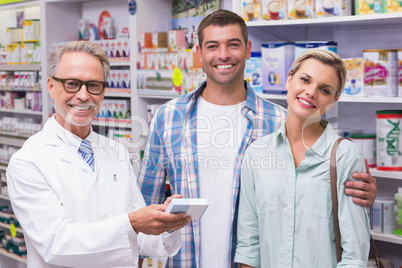 Pharmacist and costumers smiling looking at camera