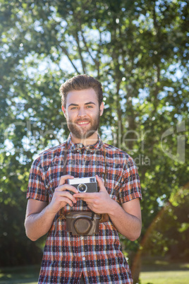 Handsome hipster using vintage camera