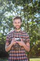 Handsome hipster using vintage camera