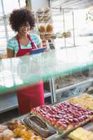 Smiling waitress using tablet pc