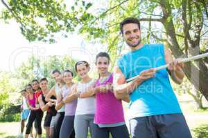 Fitness group playing tug of war