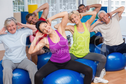 People on fitness balls exercising in gym class