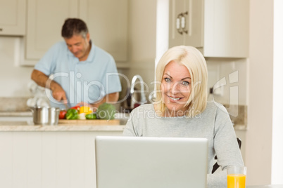 Happy mature blonde using laptop