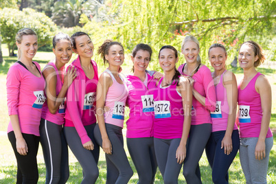 Smiling women running for breast cancer awareness