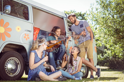 Hipster playing guitar for his friends Hipster playing guitar for his friends