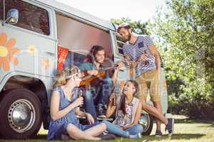 Hipster playing guitar for his friends