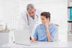 Doctors looking at laptop