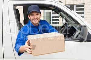 Delivery driver offering parcel from his van