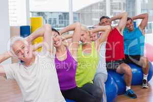People on fitness balls exercising in gym class