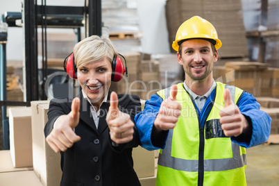 Warehouse worker and his manager giving thumbs up