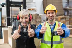Warehouse worker and his manager giving thumbs up