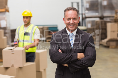 Smiling boss standing with arms crossed