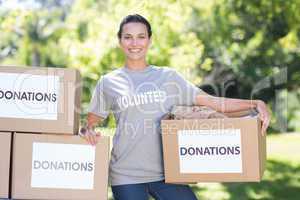 Pretty volunteer holding a donation box in park