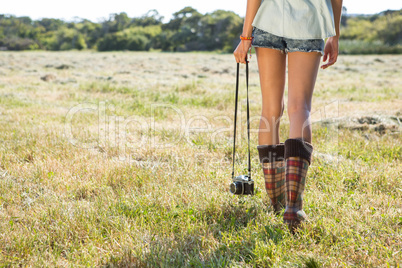 Woman walking holding retro camera