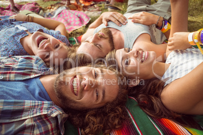 Happy hipsters lying on the grass