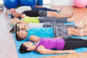 People meditating on exercise mats in fitness club