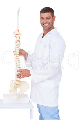 Chiropractor showing spine model to camera