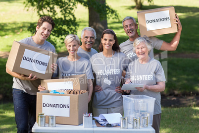 Happy volunteer family holding donations boxes