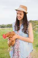 Happy brunette holding her chicken