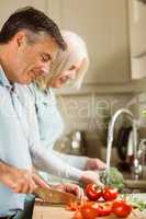 Happy mature couple preparing vegetables