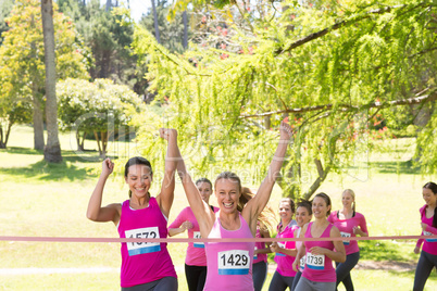 Smiling women running for breast cancer awareness