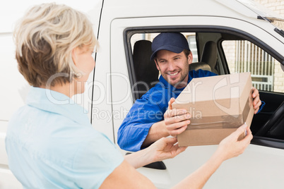 Delivery driver handing parcel to customer in his van