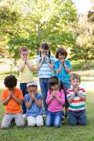 Children saying their prayers in park