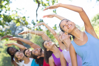 Fitness group doing yoga in park