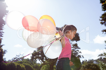 Happy little girl holding balloons
