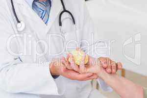 Male doctor assisting patient to hold weight