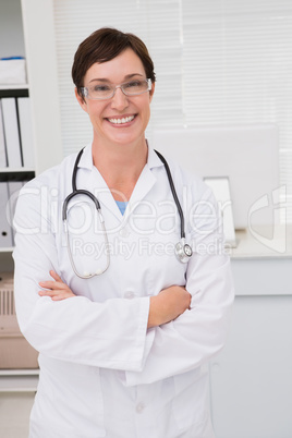 Smiling doctor with stethoscope and arms folded
