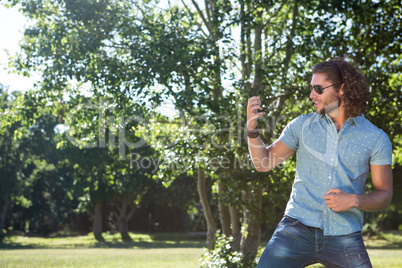 Young man playing air guitar in the park
