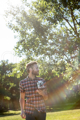 Handsome hipster using vintage camera