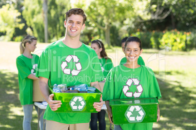 Happy environmental activists in the park with recyclables