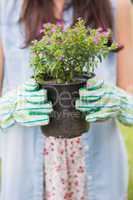 Happy woman holding potted flowers