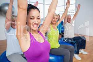 People sitting on exercise balls in fitness class