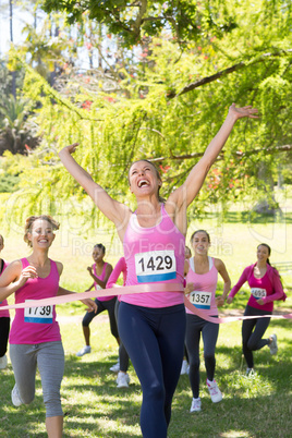 Smiling women running for breast cancer awareness