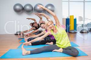 People exercising on mats in fitness club
