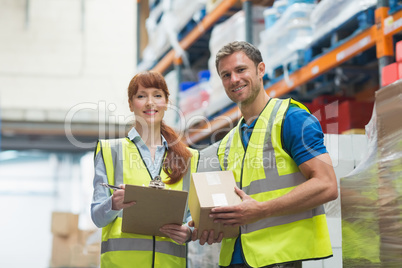 Smiling warehouse manager and delivery man