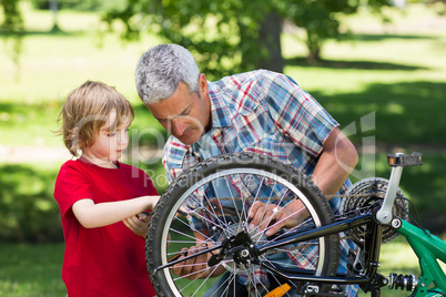 Father and his son fixing a bike