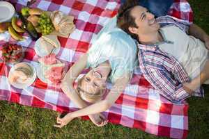 Happy couple lying together at the park