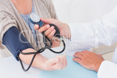 Cropped image of doctor checking patients blood pressure