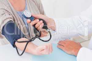 Cropped image of doctor checking patients blood pressure