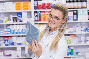 Smiling pharmacist using tablet pc