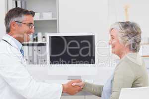 Doctor and female patient shaking hands