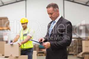 Boss using digital tablet in warehouse