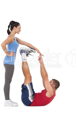 Trainer helping her client stretch legs