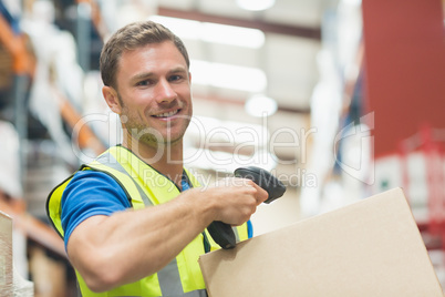 Smiling manual worker scanning package