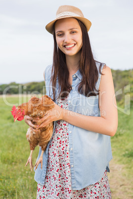 Happy brunette holding her chicken
